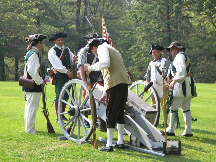revolutionary war reenactment soldiers surround a cannon